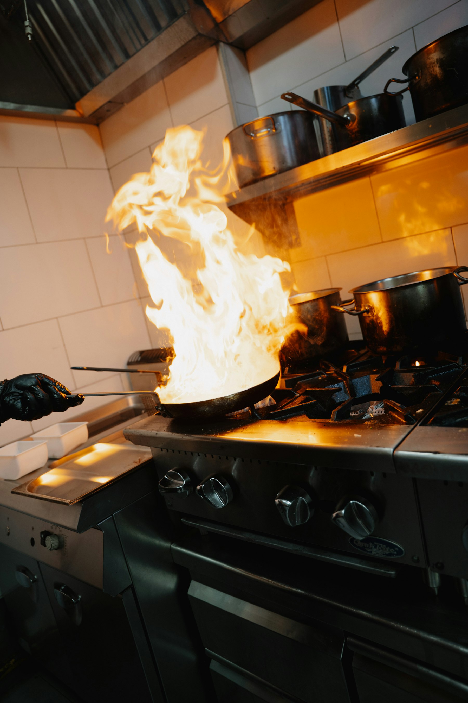 Chef working over a flame in a professional kitchen